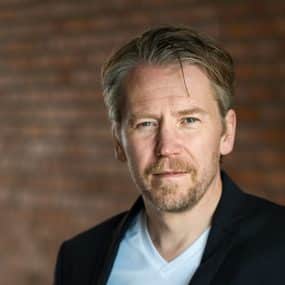 Jesper Falkheimer står framför en tegelväg utomhus